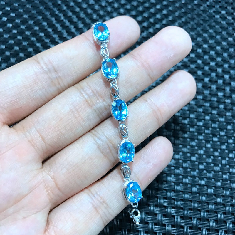 Bracelet en topaze bleue et argent sur une main