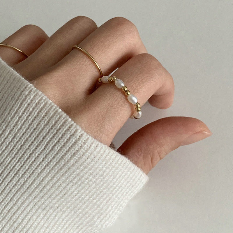 Bague en perle millet naturelle sur une main