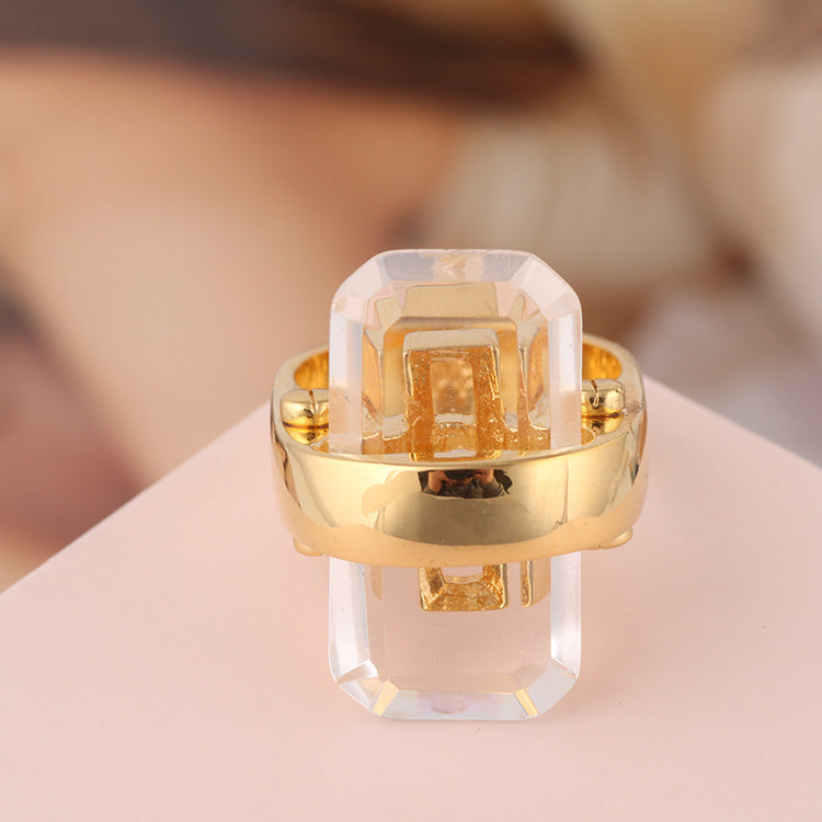 Bague dorée avec pierre transparente rectangulaire