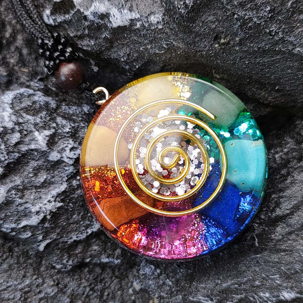 Pendentif chakra multicolore en jade onyx sur fond de pierre