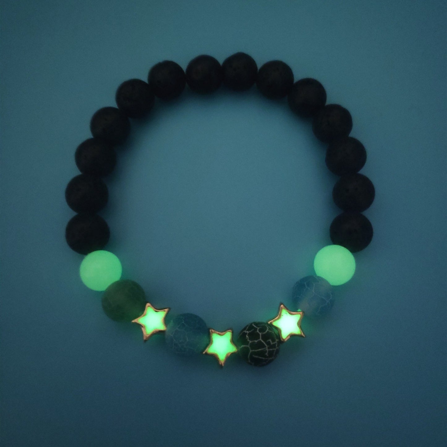 Bracelet en pierre naturelle avec étoiles lumineuses vertes.