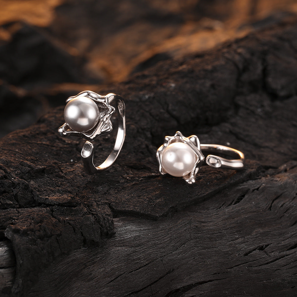 Deux bagues en argent avec perles sur fond de bois