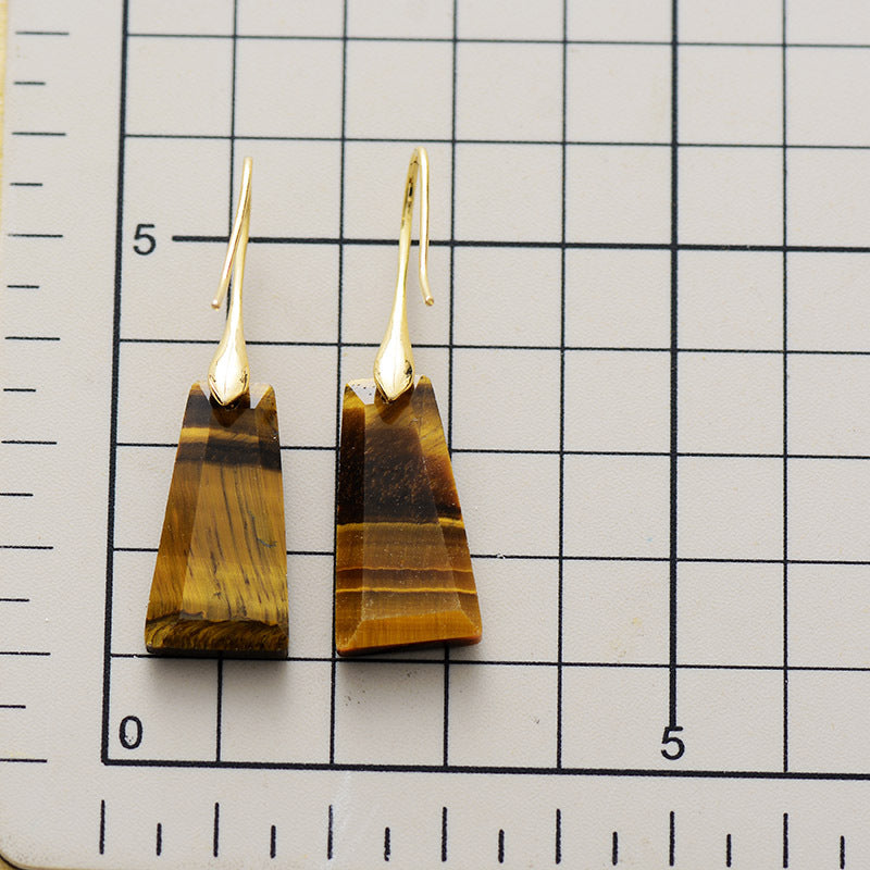 Boucles d'oreilles marron sur fond quadrillé