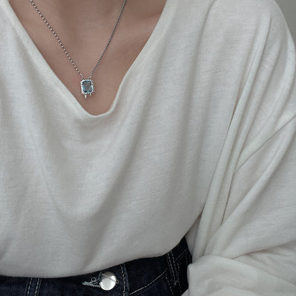 Collier en argent S925 avec zircon bleu sur pull blanc.