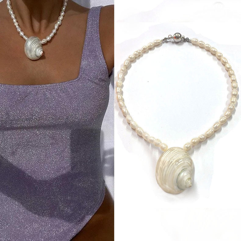 Collier en perles baroques et coquillage sur fond blanc