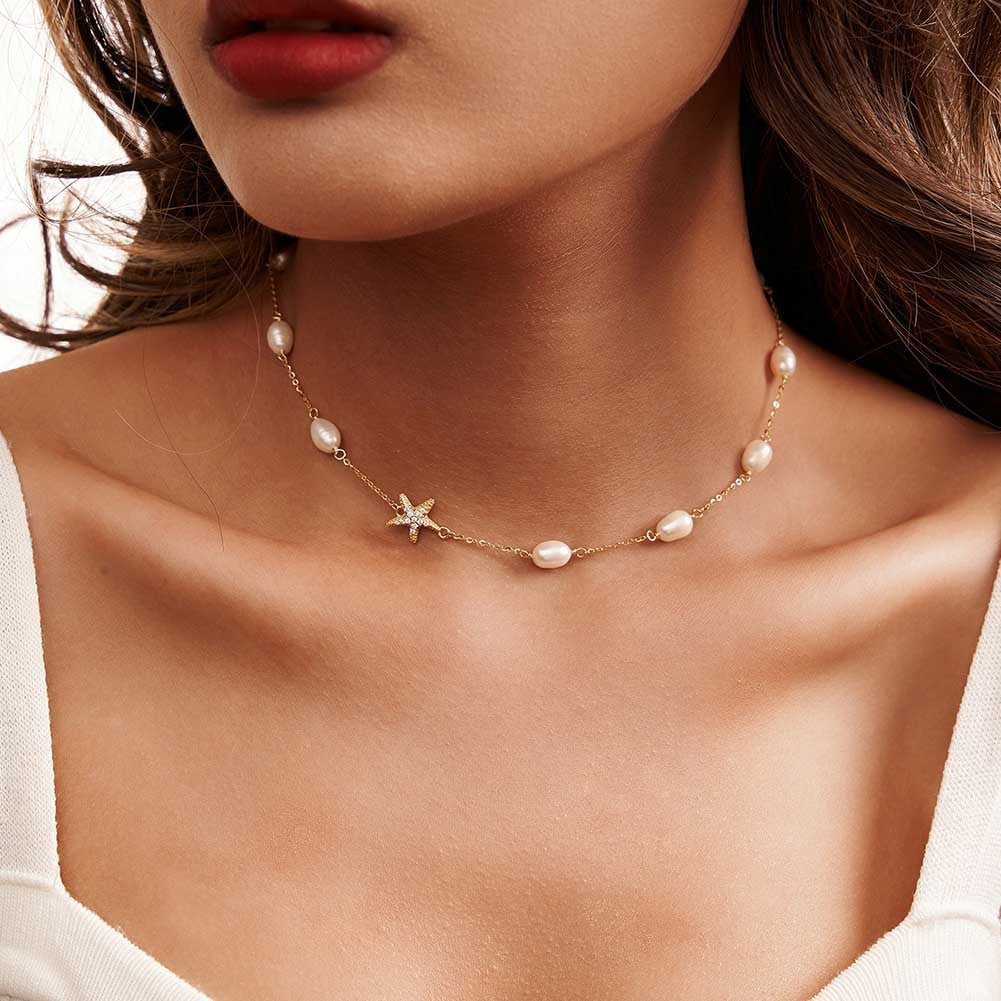 Collier perles et étoile de mer porté par une femme