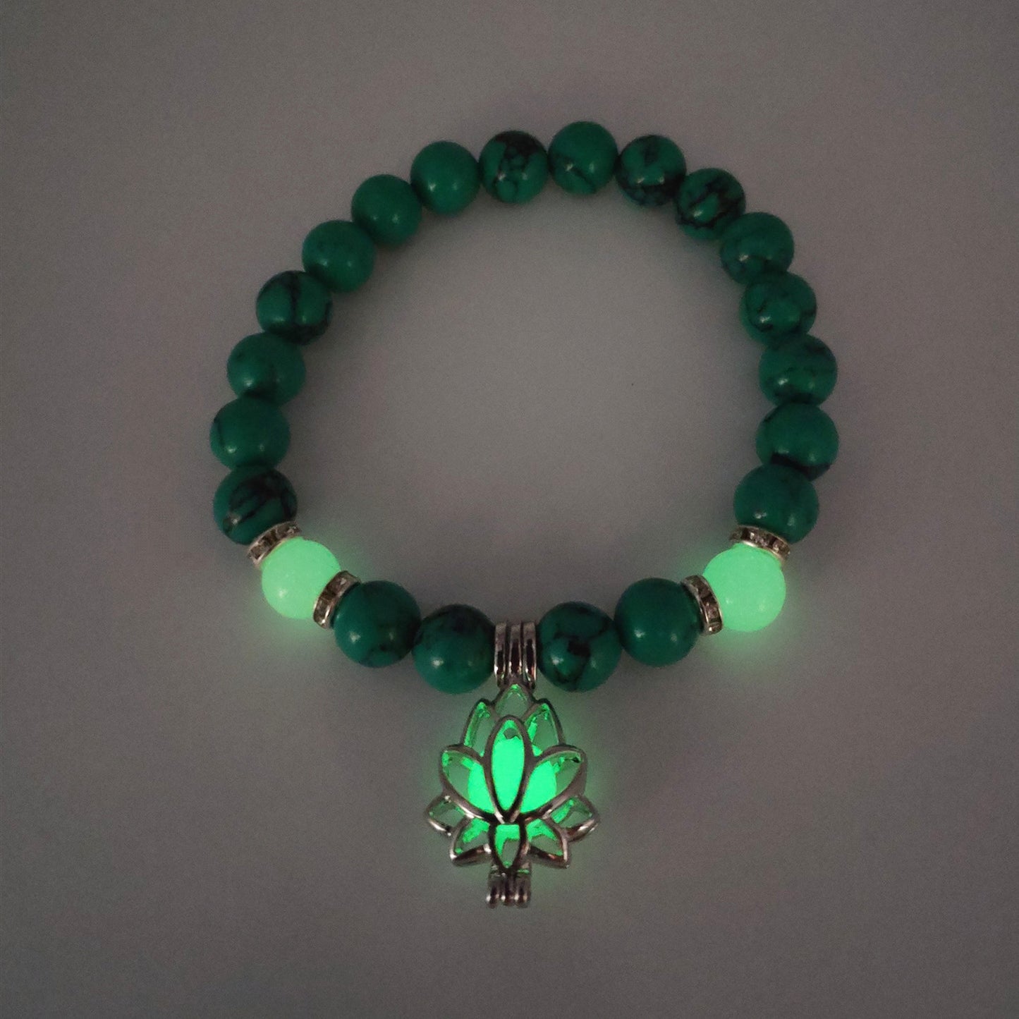 Bracelet vert avec pierres lumineuses et lotus.