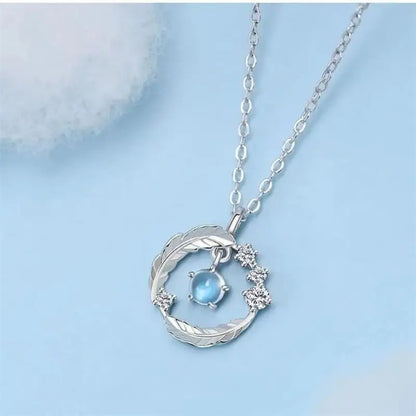 Collier plume argent 925 avec pierre de lune sur fond bleu