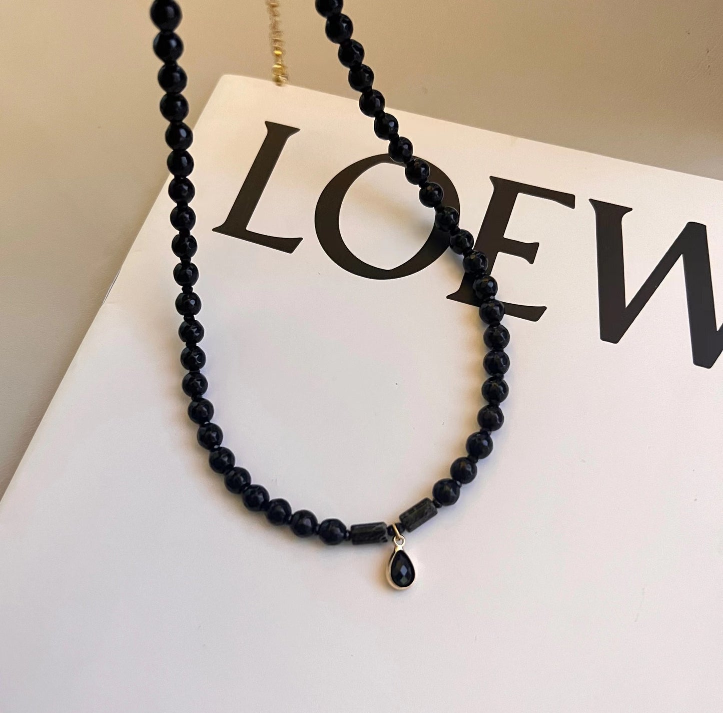 Collier de perles noires avec pendentif sur livre