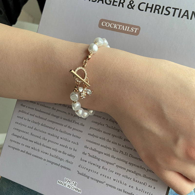 Bracelet perle avec pendentif sur poignet, fond texte.