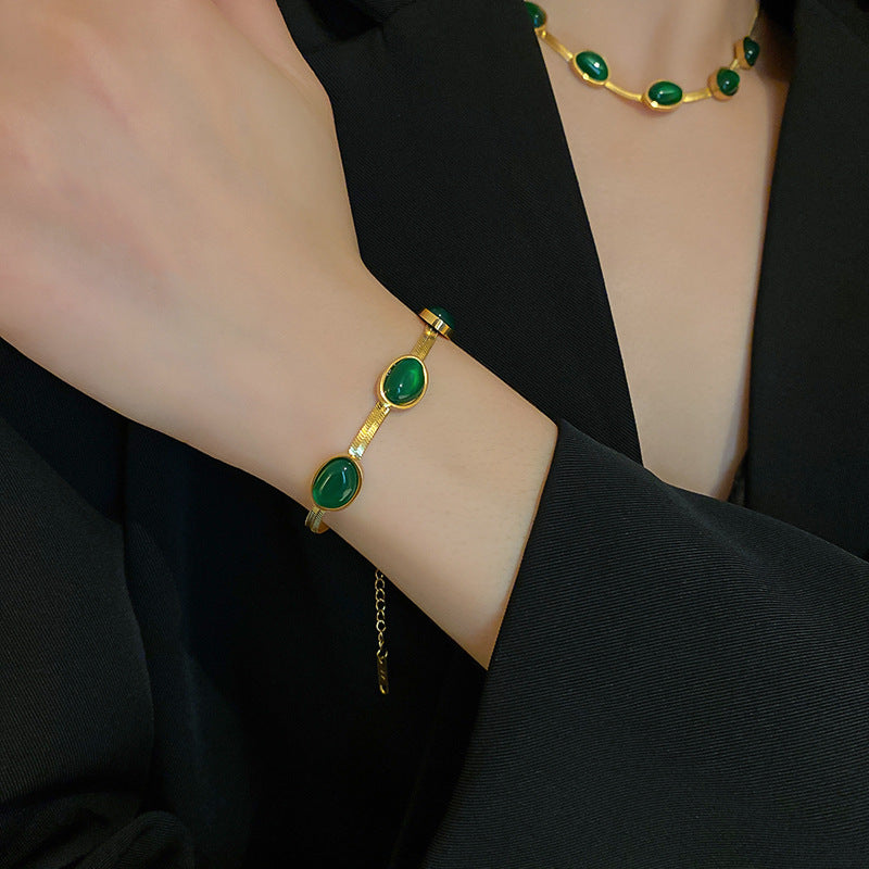 Ensemble de collier et bracelet en pierre verte porté par une femme