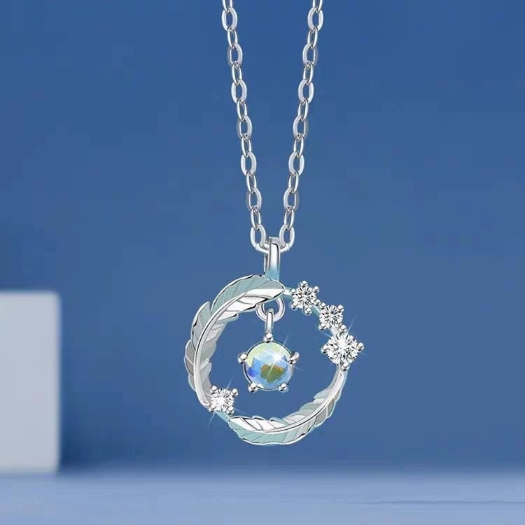 Pendentif plume argent 925 avec pierre de lune sur fond bleu