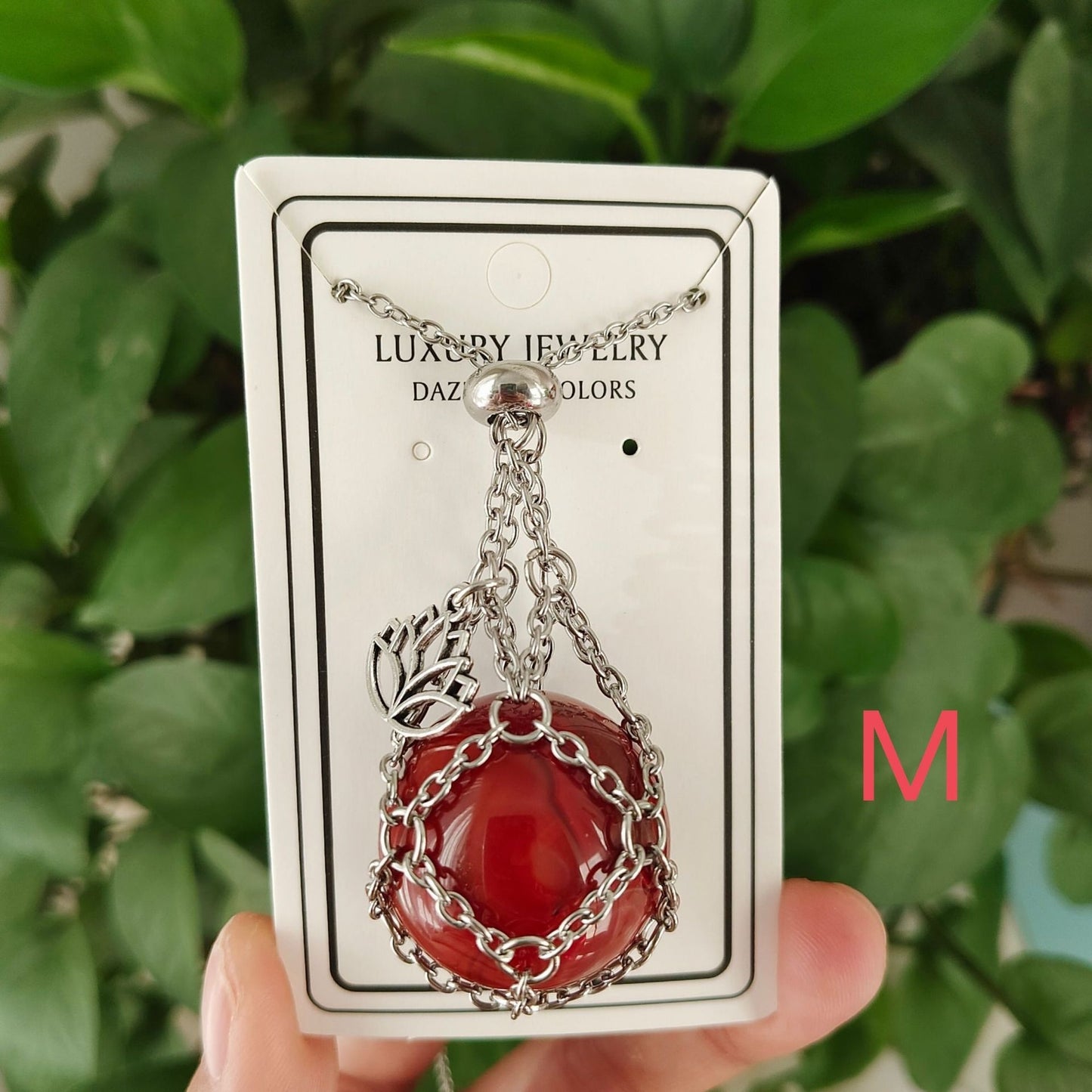 Collier cristal rouge avec pendentif lotus sur carte