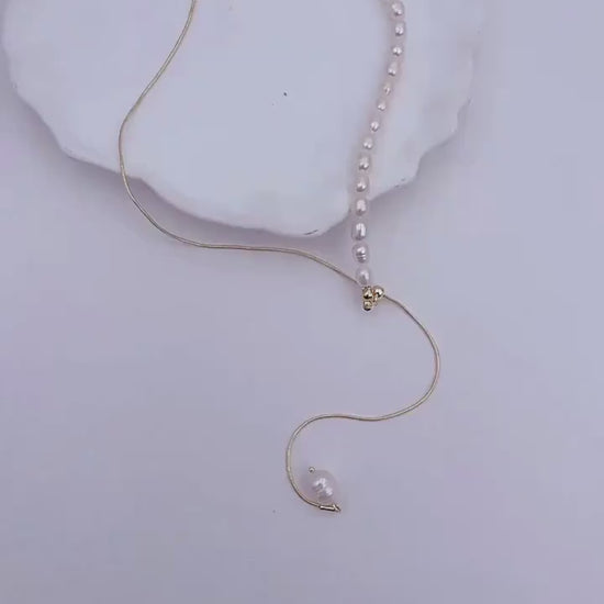 Vidéo montrant deux mains entrain de manipuler le collier en perle d'eau douce naturelle